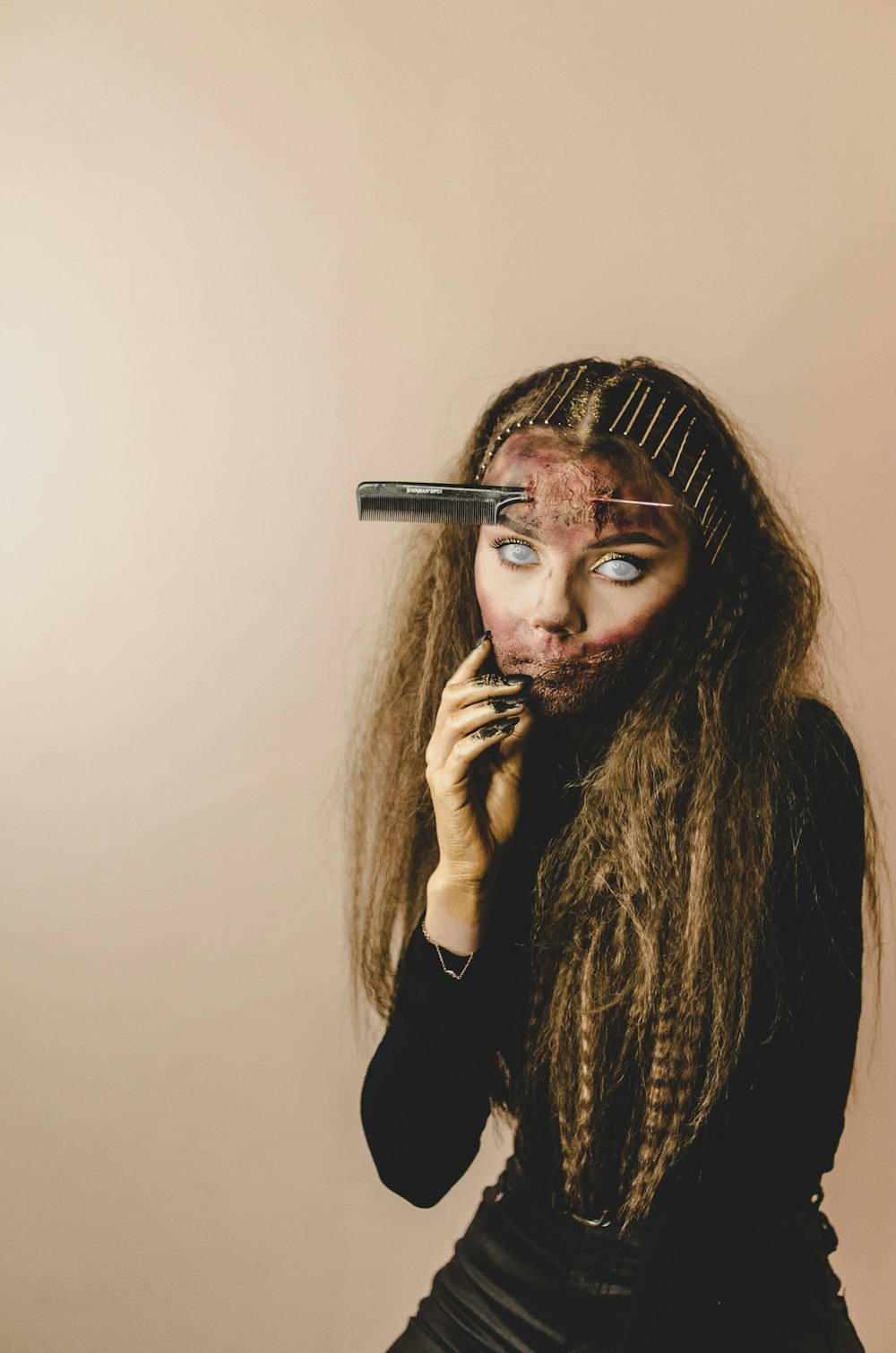 woman in black long sleeve shirt holding her face