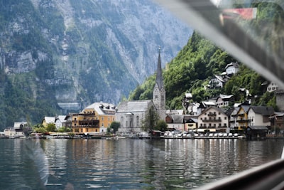 white and brown houses near body of water and mountain during daytime österreich zoom background