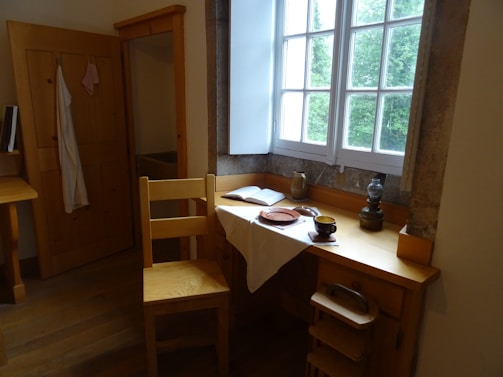 A cozy writing desk by a window overlooking a peaceful Portuguese landscape.