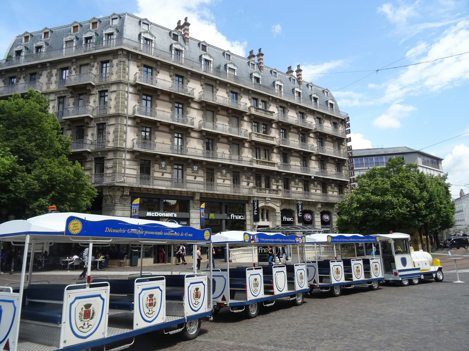 white and blue bus in front of brown concrete building during daytime