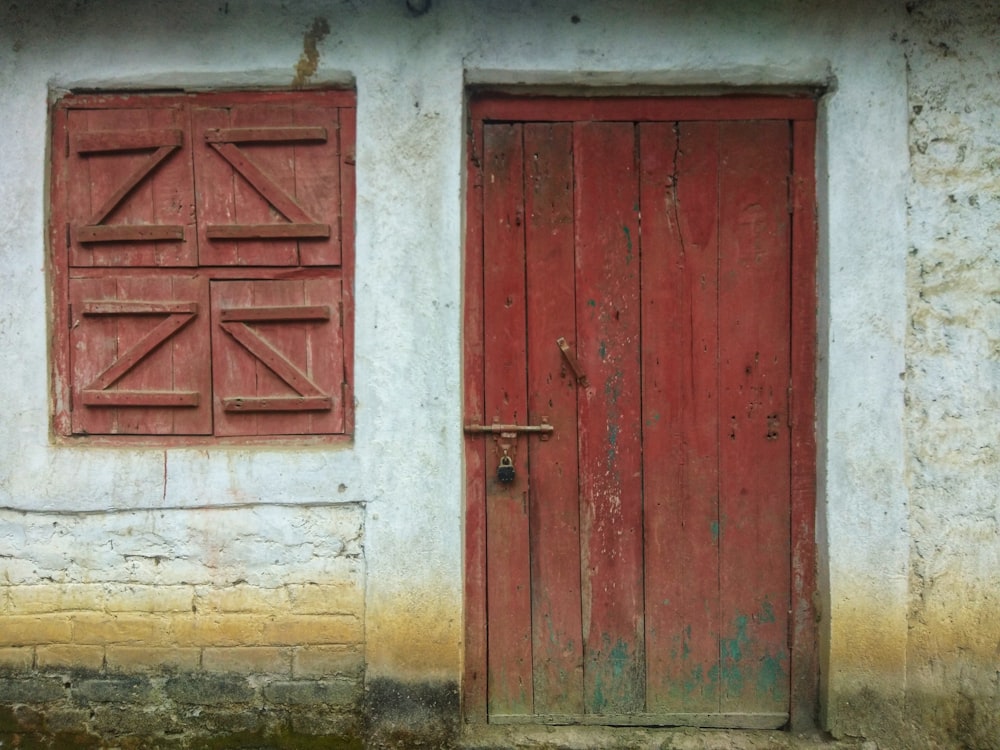 灰色のコンクリートの壁に赤い木製のドア