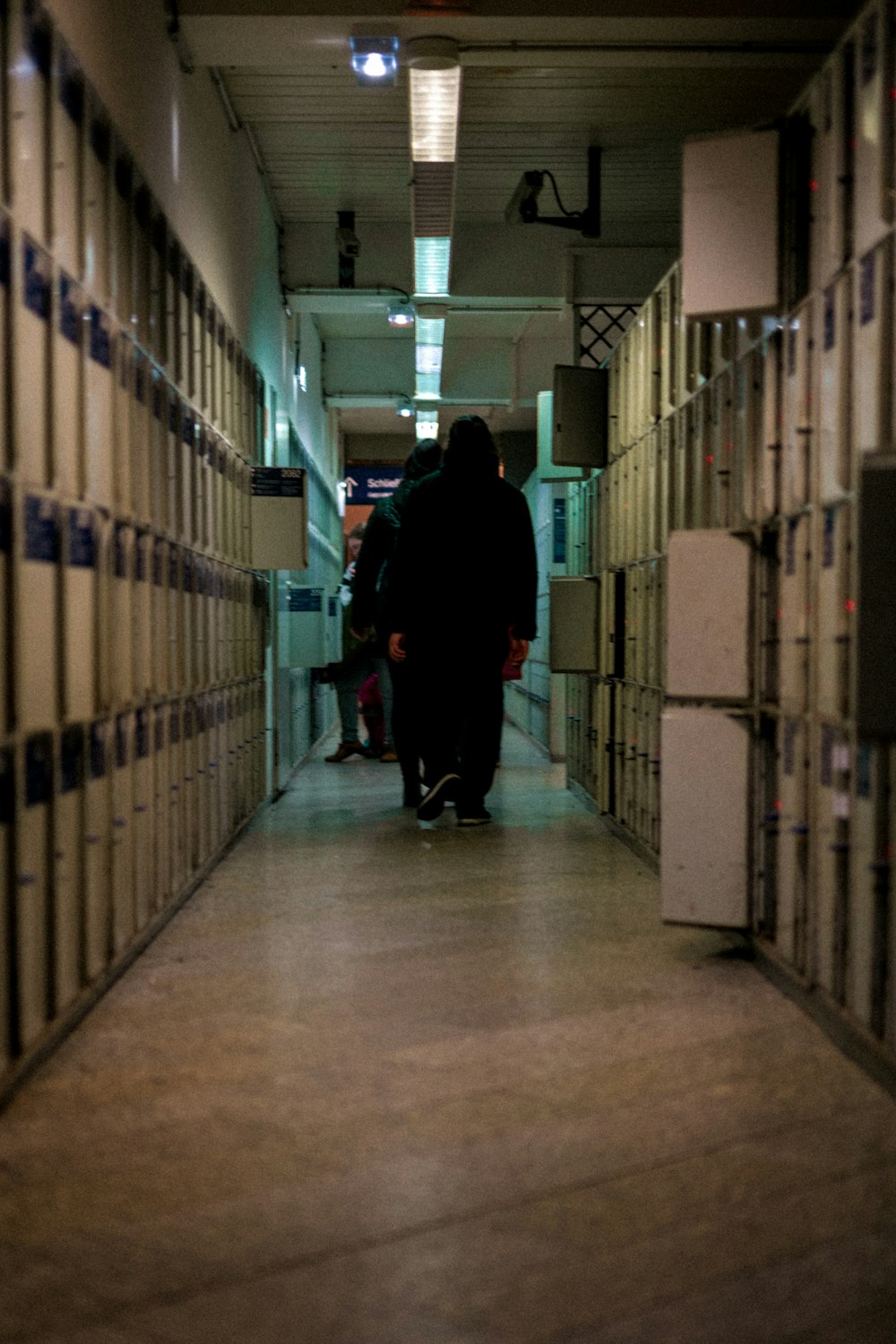 man in black jacket walking on hallway