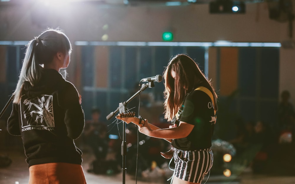 woman in black and white stripe shirt singing