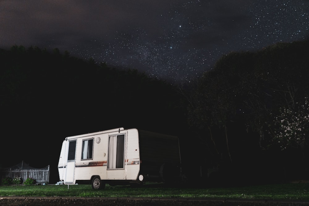 white and gray camper trailer under starry night