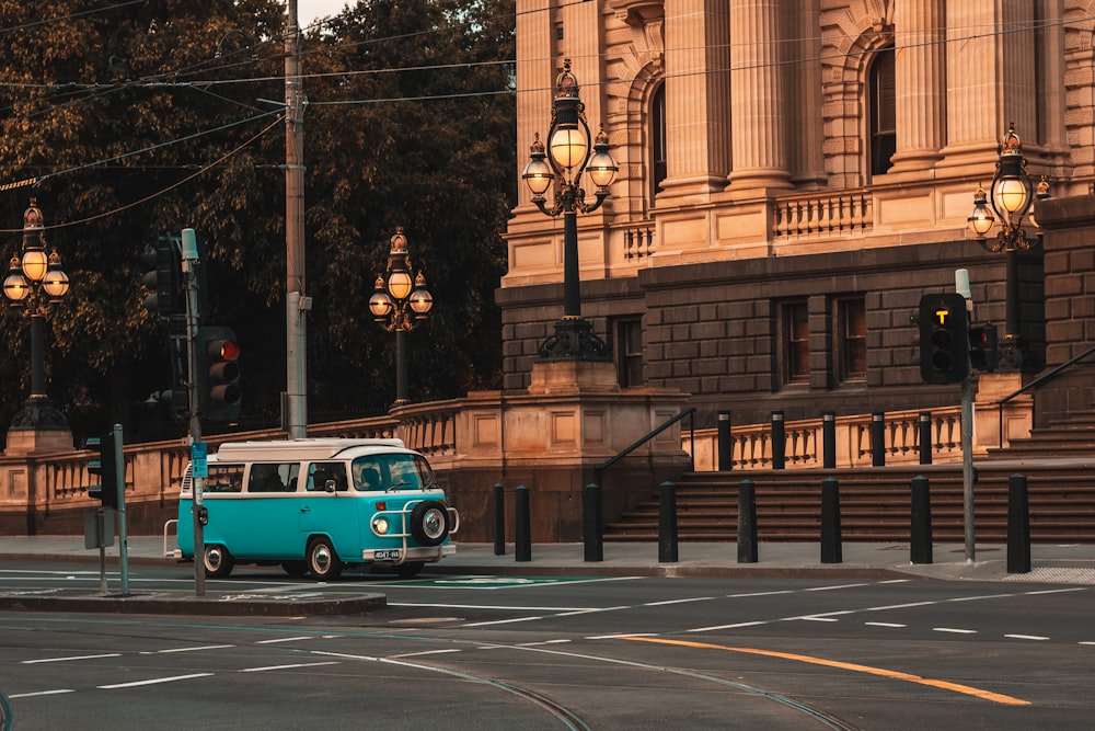 Volkswagen T-2 bleue et blanche garée à côté d’un bâtiment en béton brun pendant la journée