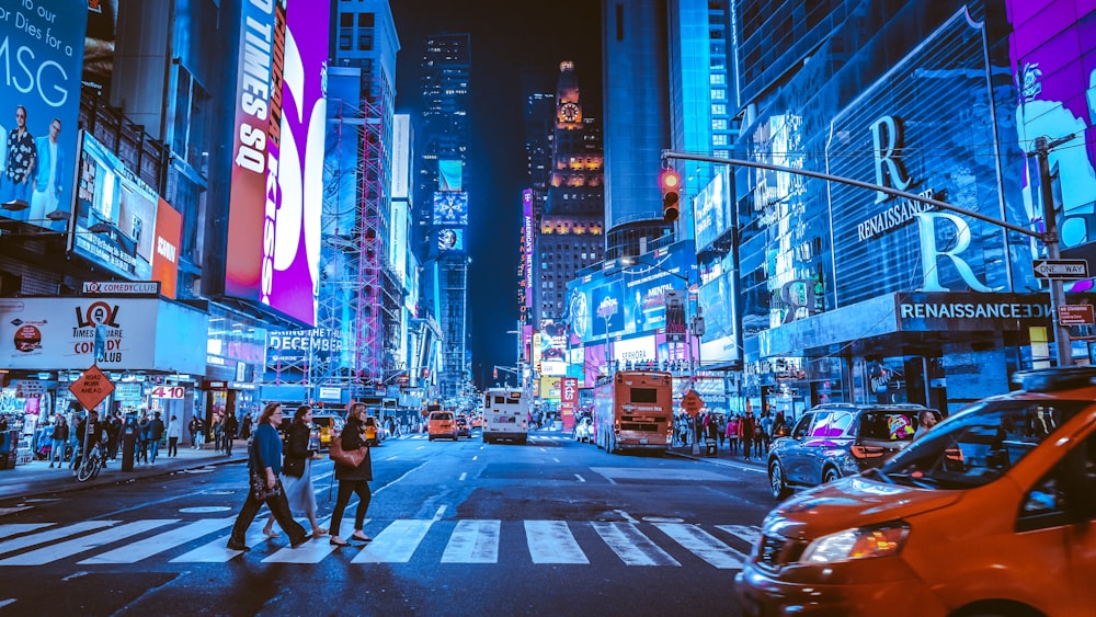 pessoas andando na faixa de pedestres durante a noite