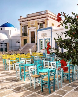 Sunlit outdoor seating area with yellow and calypso blue decor, palm tree mosaic walls at the market central in Carcaixent