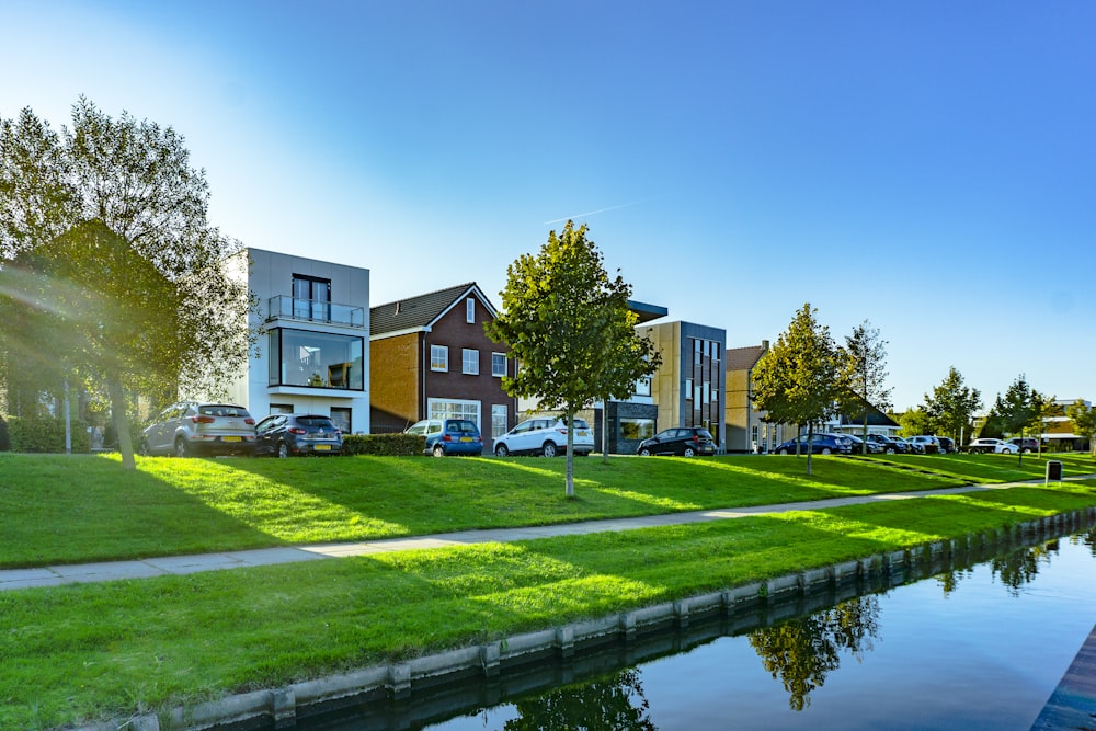 Weißes und braunes Haus in der Nähe von grüner Wiese und Gewässer während des Tages