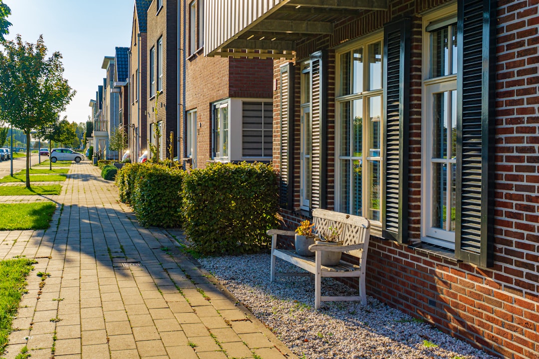 brown wooden bench near brown brick building during daytime