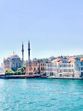 white and brown concrete building near body of water during daytime