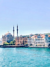 white and brown concrete building near body of water during daytime