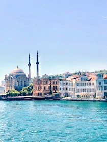 white and brown concrete building near body of water during daytime
