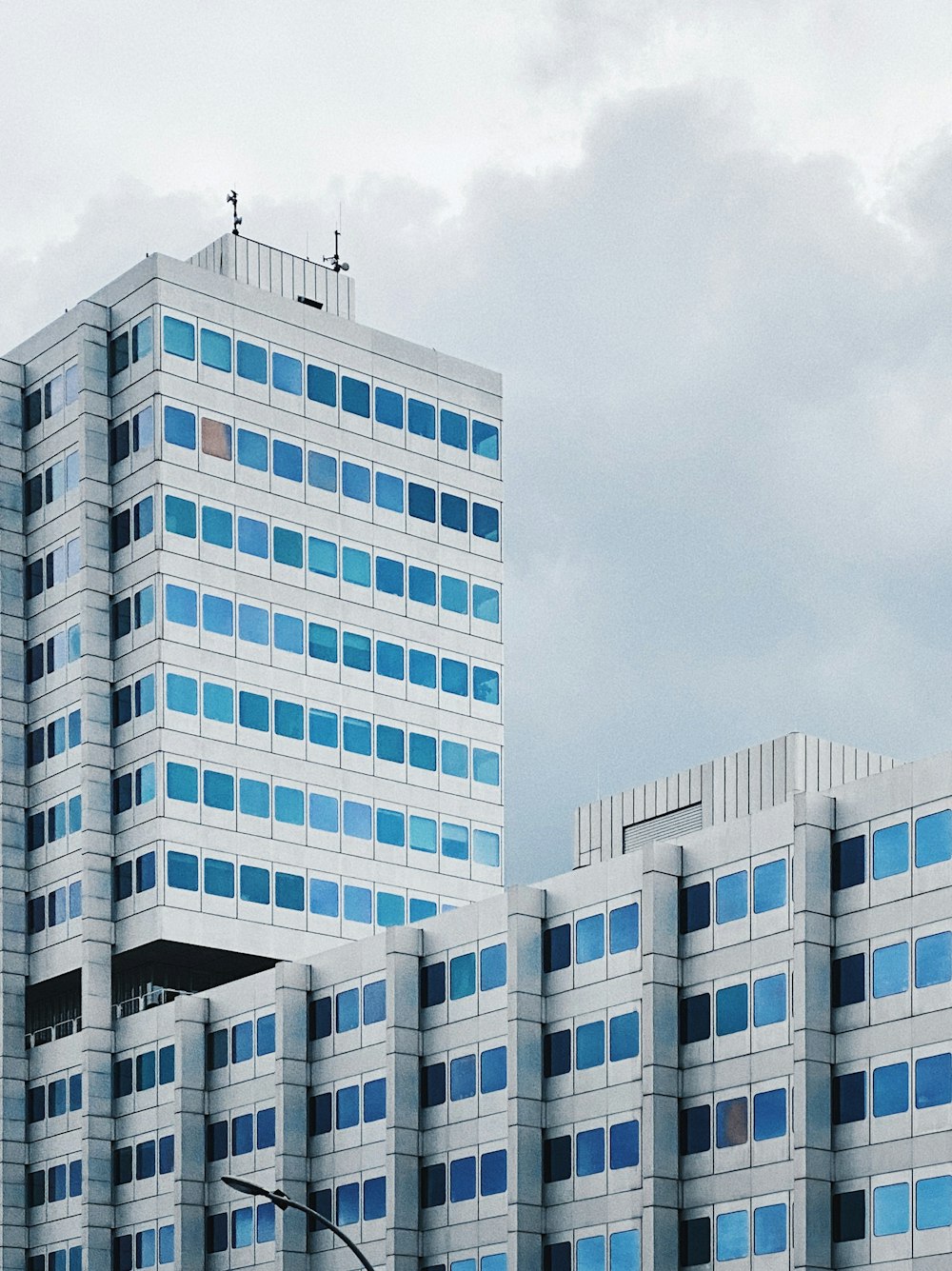 white concrete building under white clouds during daytime