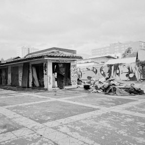 Black and white photo of an abandoned urban building with graffiti and peeling paint.