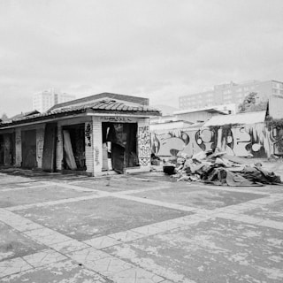 Black and white photo of an abandoned urban building with graffiti and peeling paint.