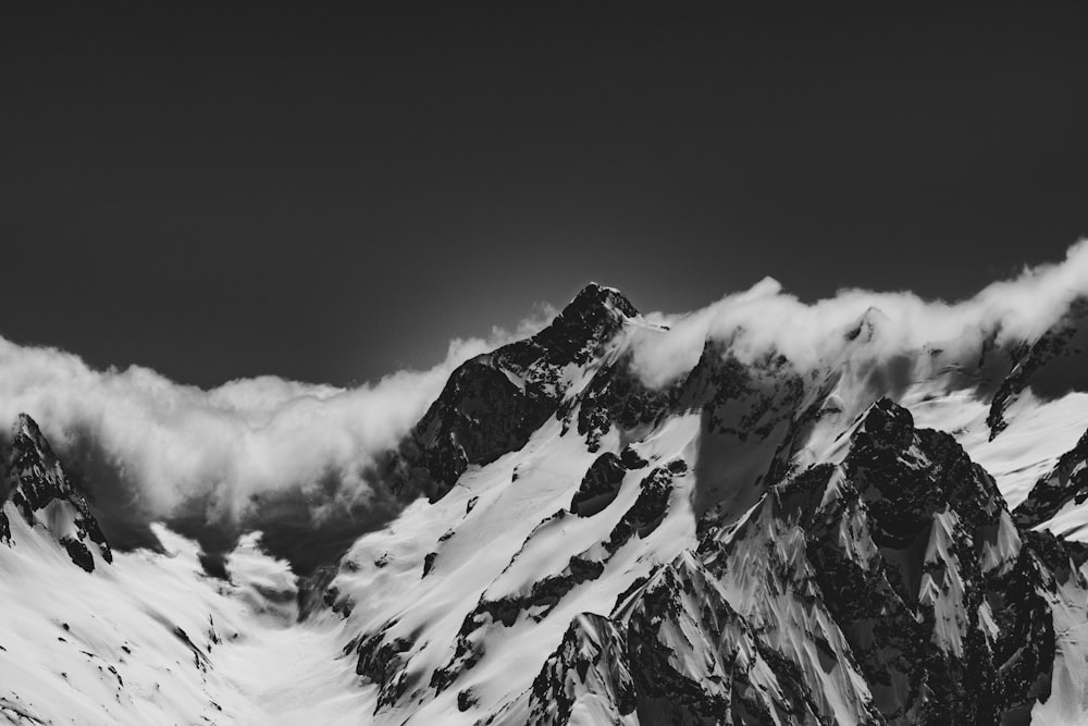 snow covered mountain under cloudy sky