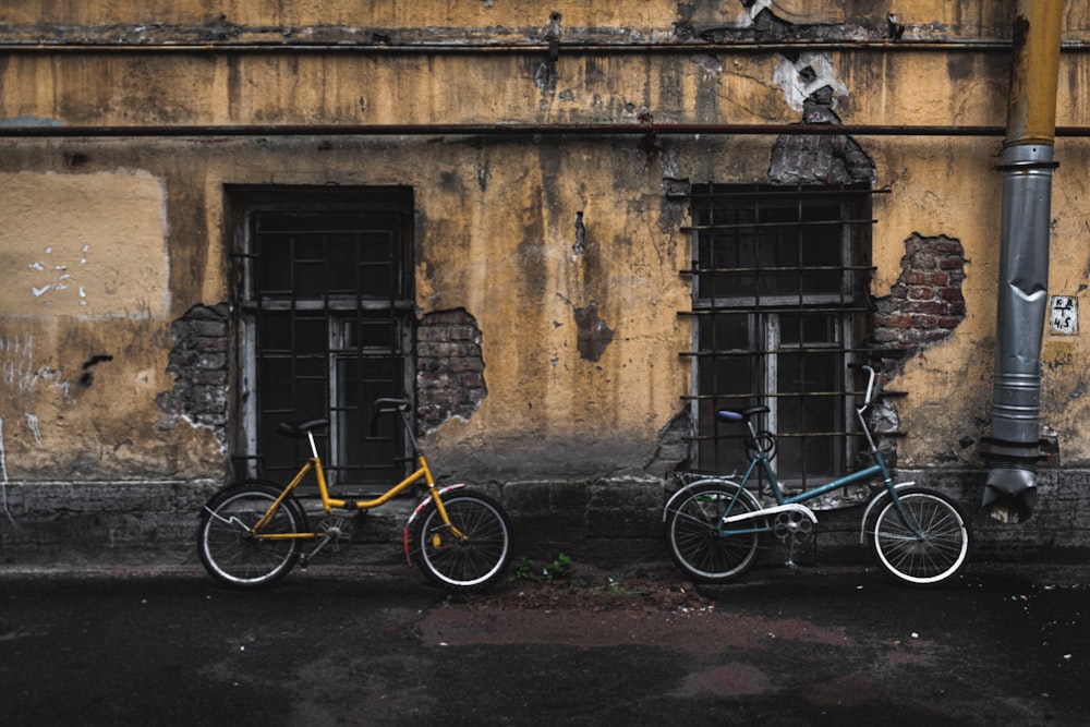 yellow and black bicycle beside brown brick wall