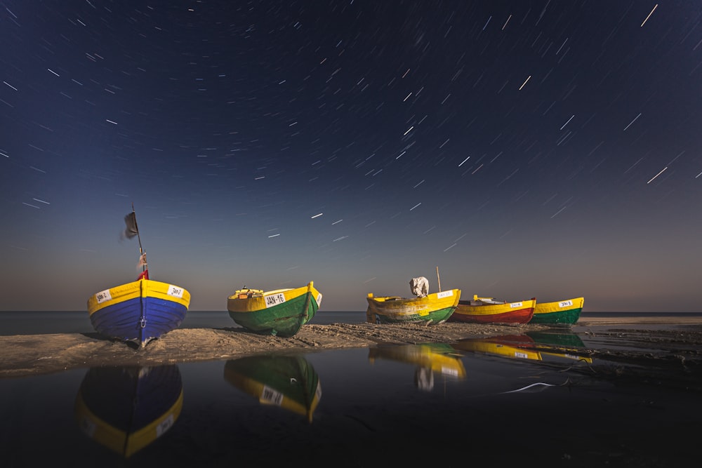 green and yellow boats on water during night time