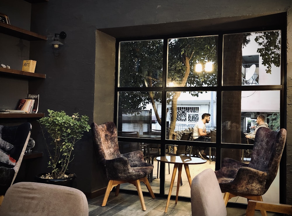 people sitting on chair near glass window