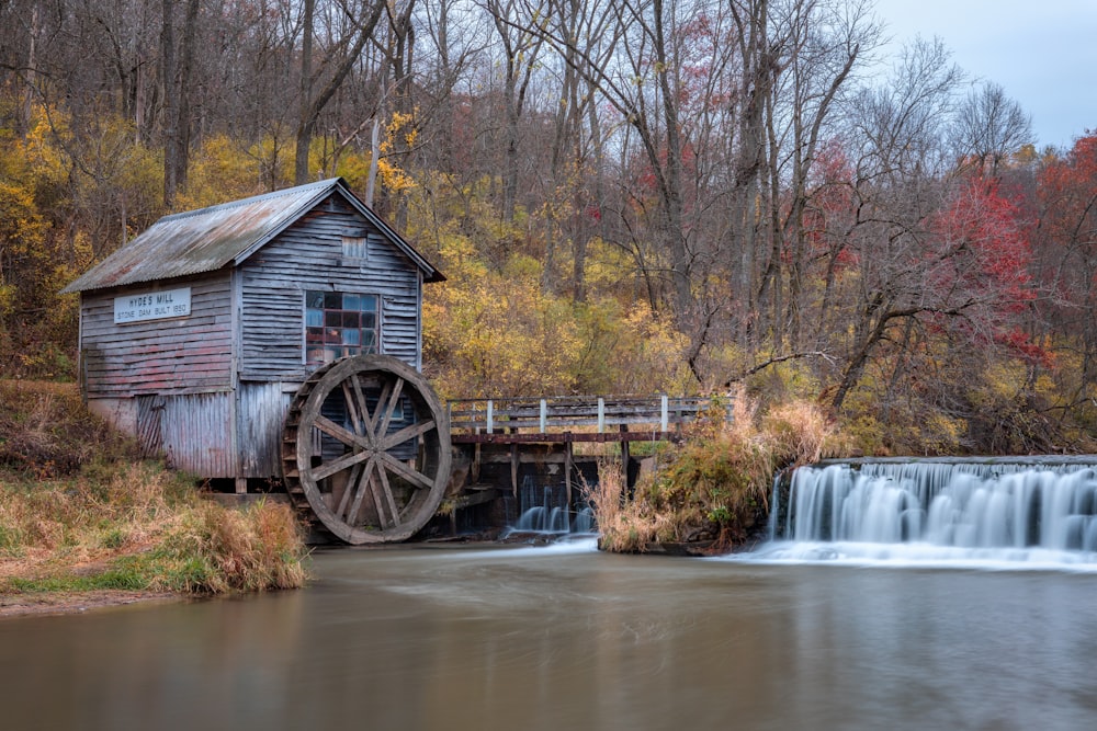 eine Wassermühle mit einem Wasserfall im Hintergrund