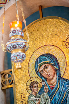 Close-up of a vibrant religious mosaic inside a historic Mani chapel, showing intricate tile work.