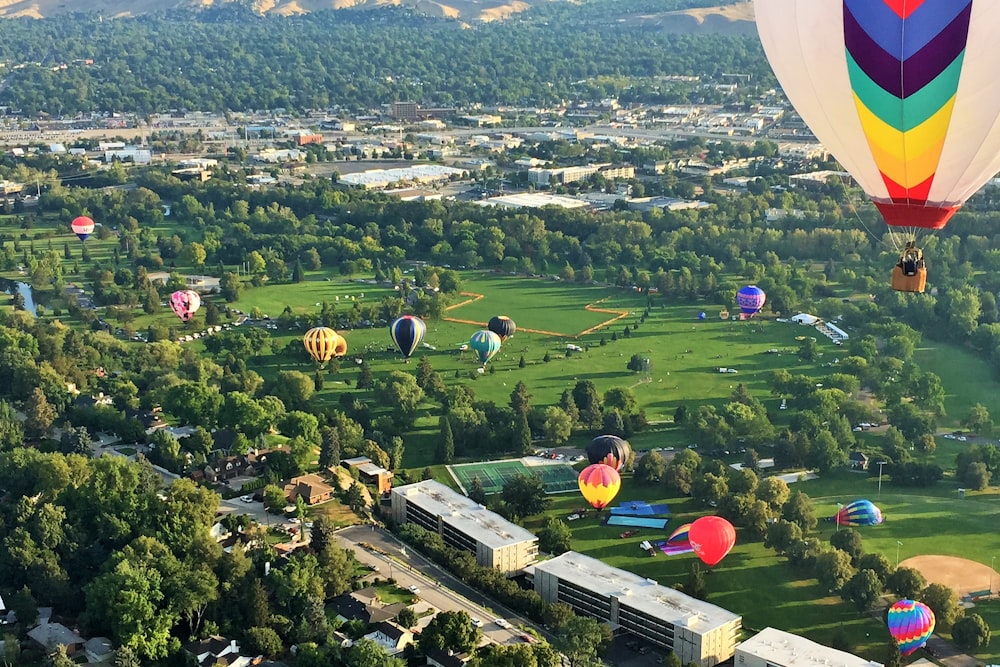 Luftaufnahme des grünen Rasenfeldes mit Heißluftballons