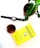 A pot with a green plant is placed on a white surface alongside a smartwatch, a glass of tea, and a yellow book titled 'Hooked' by Nir Eyal.