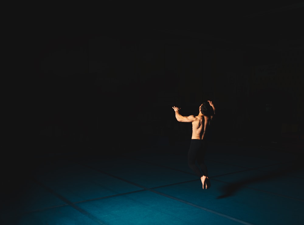 woman in black tank top and black shorts standing on blue floor