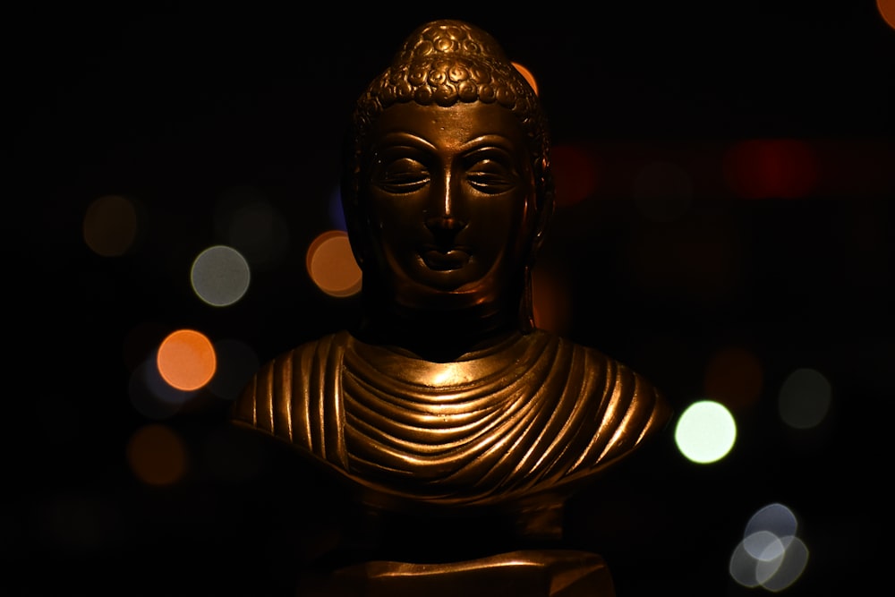 gold buddha head bust in bokeh photography