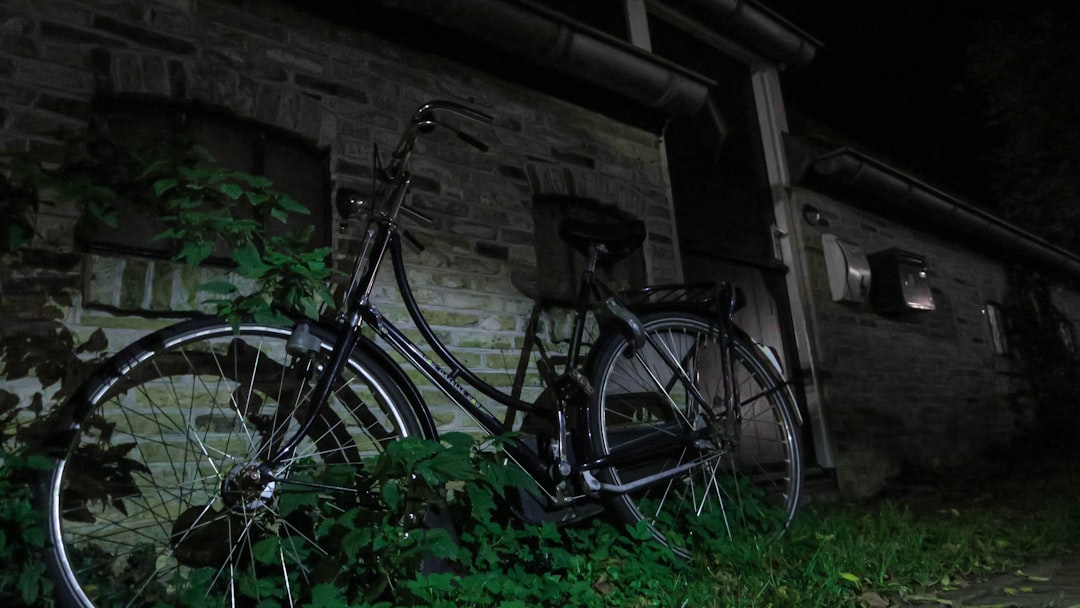black commuter bike near brown wooden wall