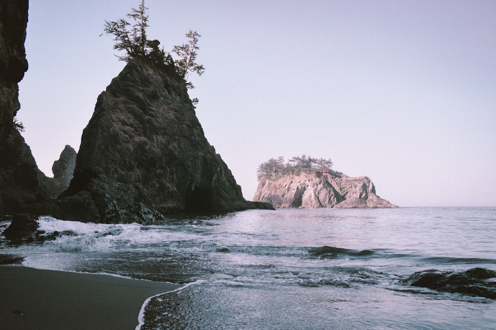 brown rock formation on sea water during daytime