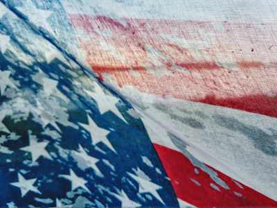A cozy sweatshirt hanging on a rustic wooden rack featuring a classic patriotic design with stars and stripes.