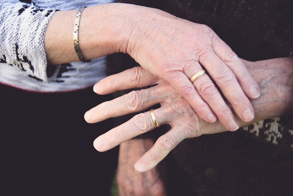 Person, die silbernes Armband und silbernes Armband trägt