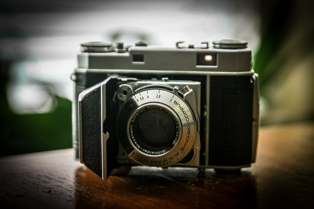 black and silver camera on brown wooden table