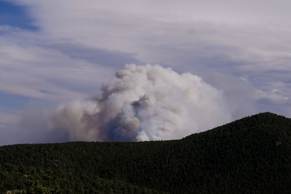 white clouds over green mountain