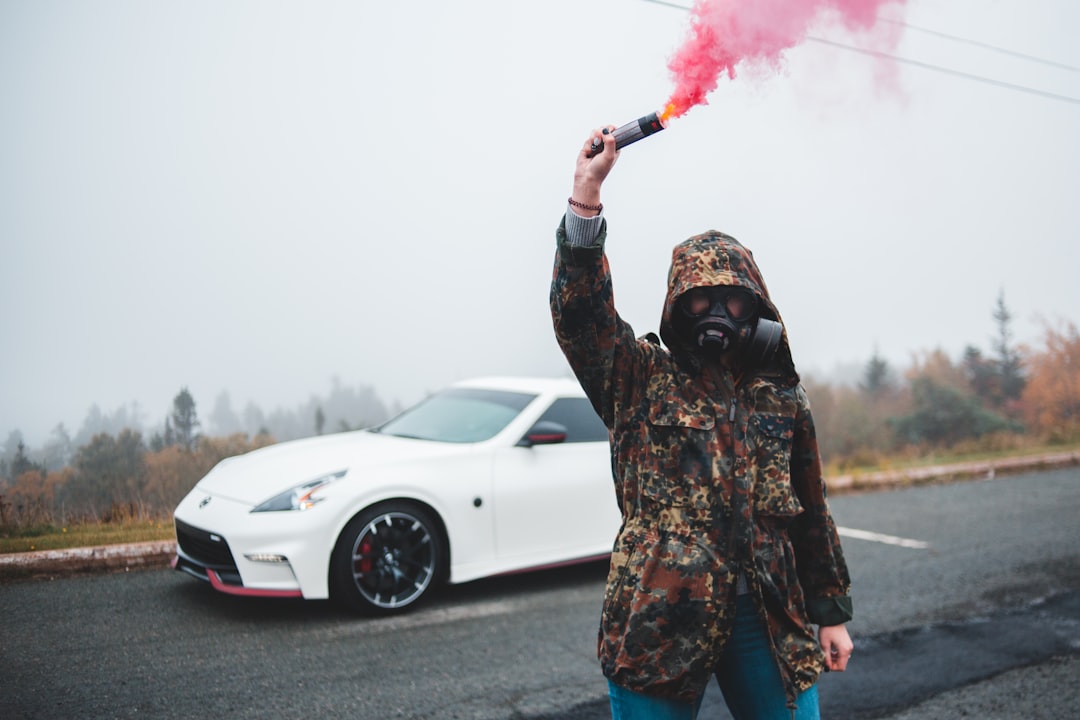 man in brown green and black camouflage jacket holding red and white powder