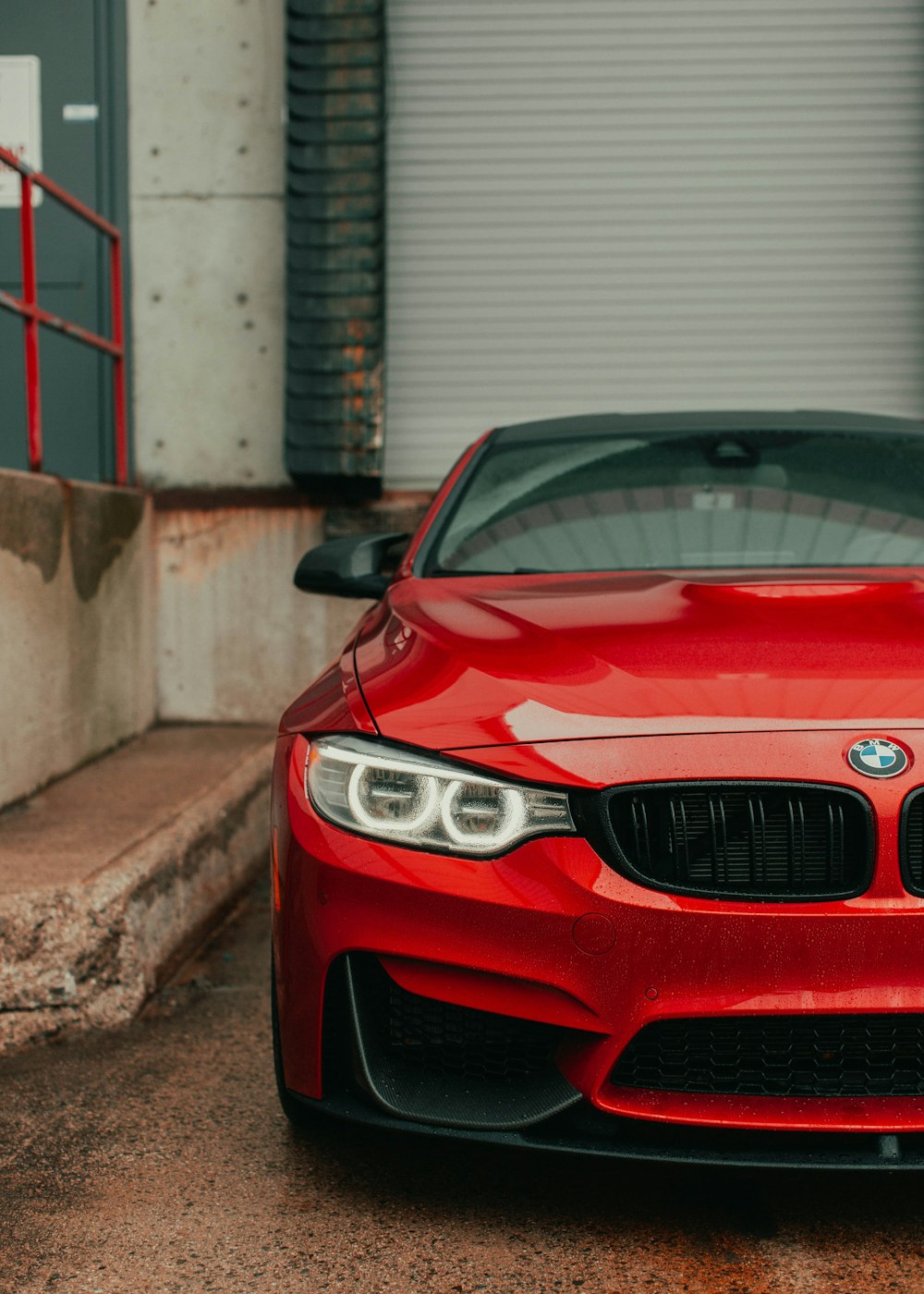 red bmw m 3 parked on gray concrete floor during daytime