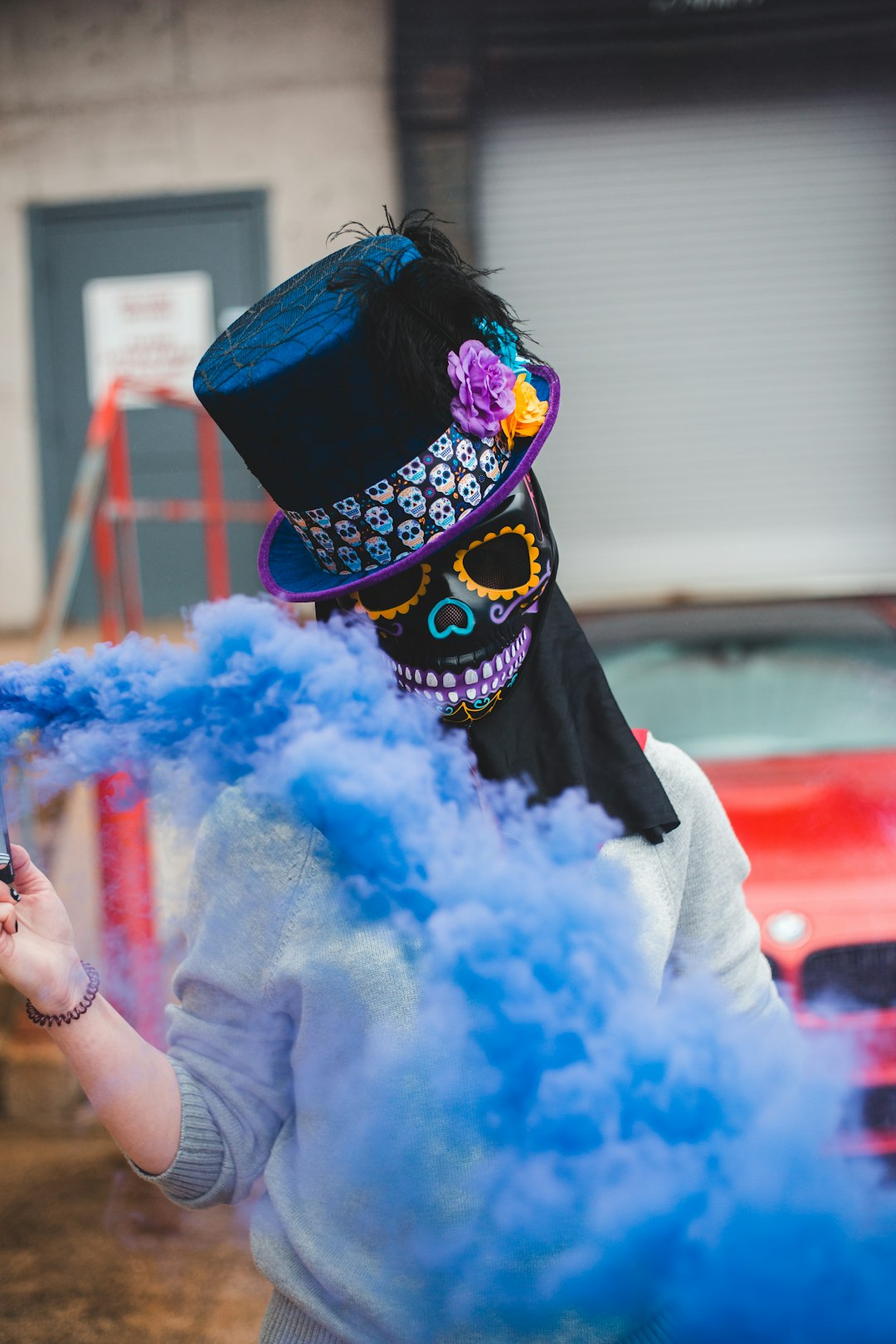 person in black and white hat holding blue powder