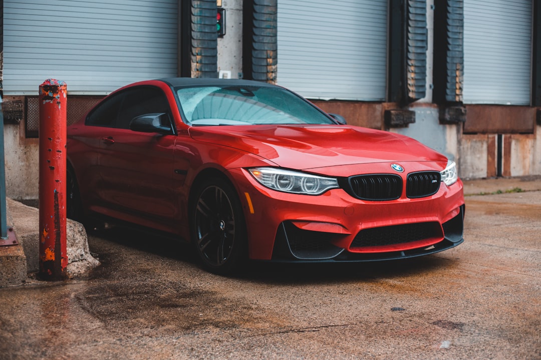 red bmw m 3 parked near white building