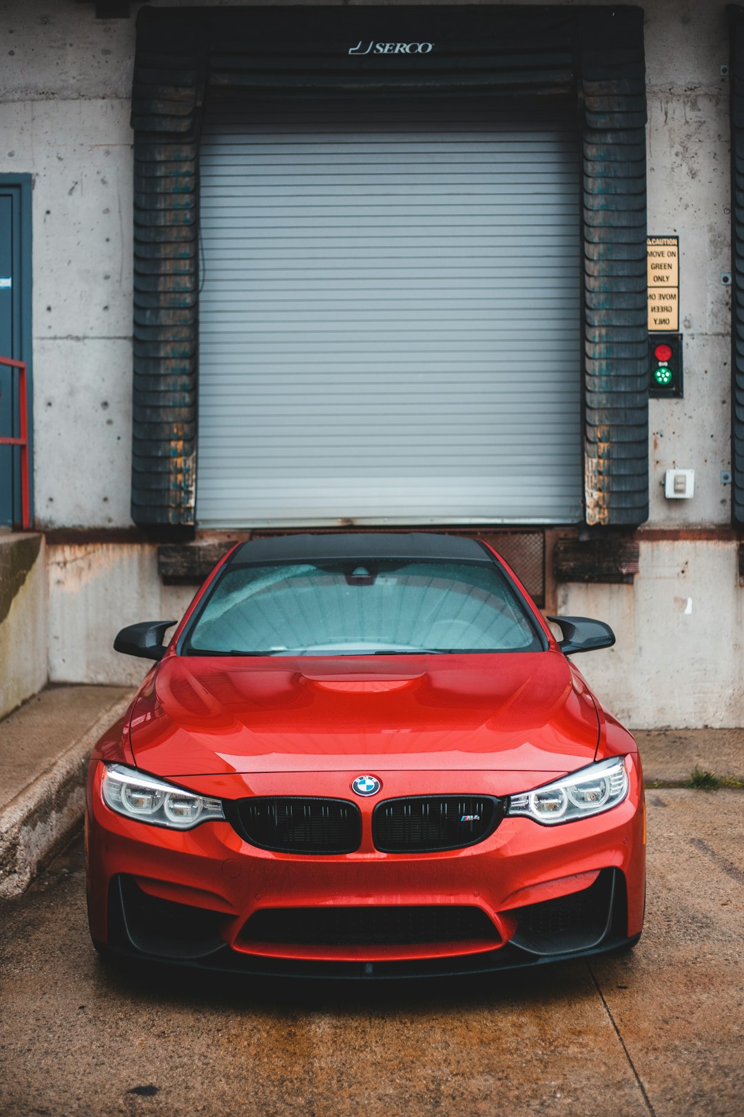 red bmw m 3 parked near garage door