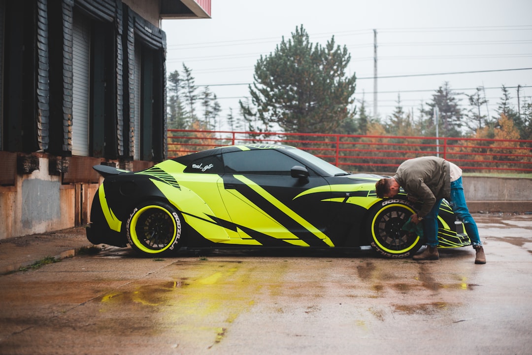 man in gray jacket and gray pants riding yellow and black sports car