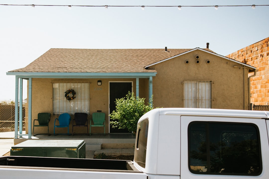 white van parked in front of brown concrete building during daytime