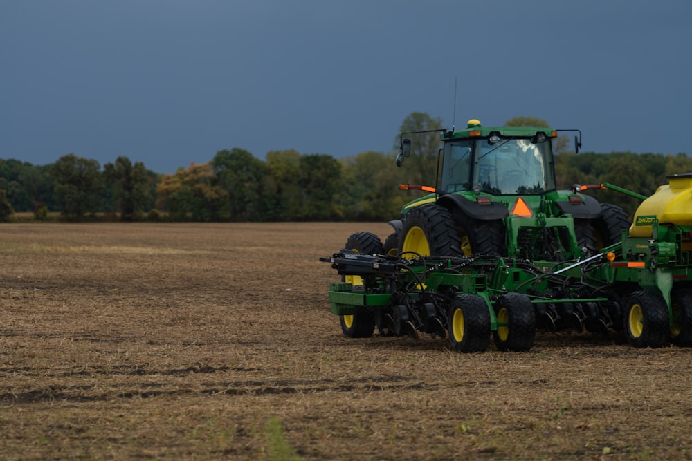 green and yellow tractor on brown field during daytime