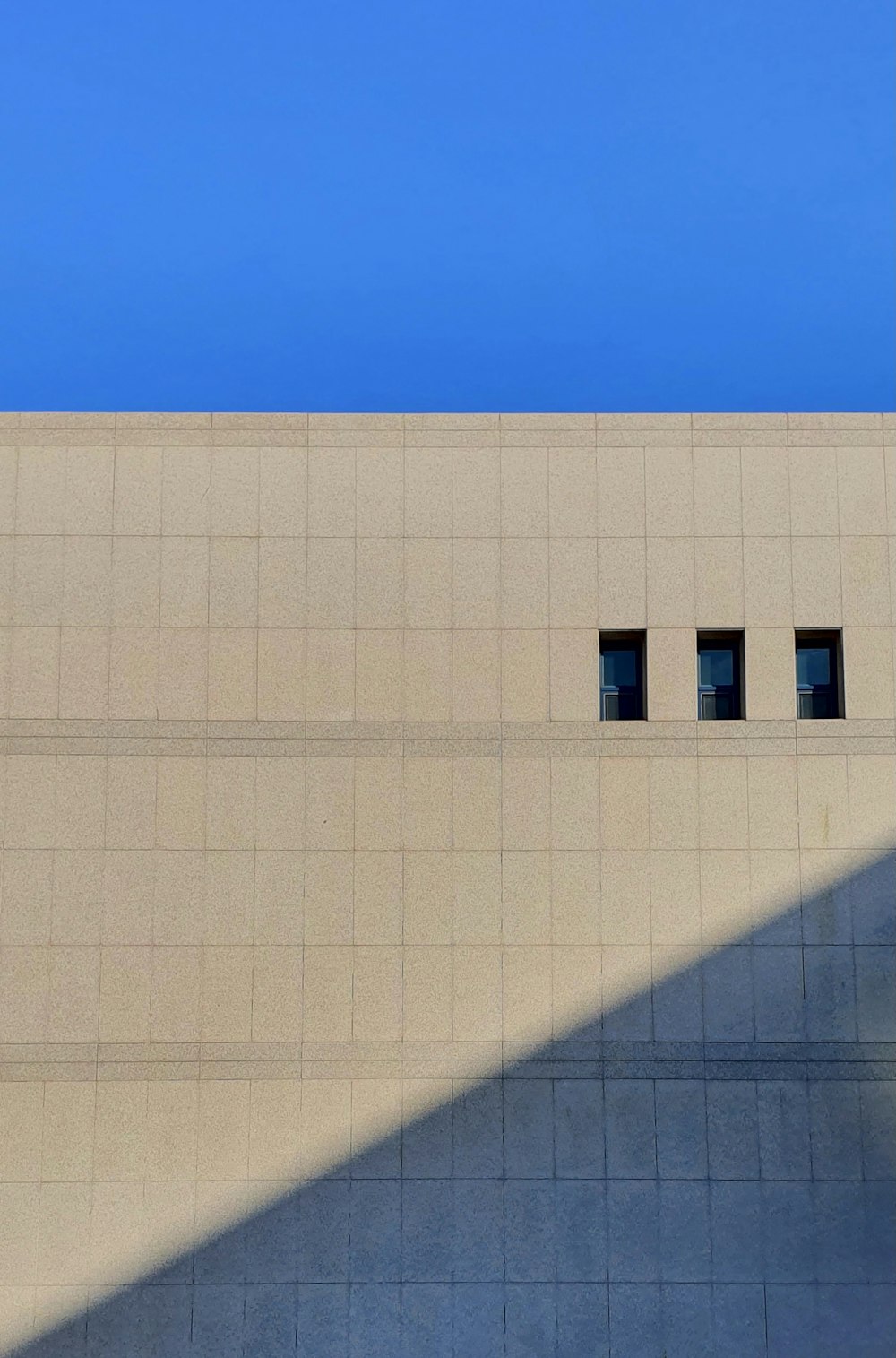 Weißes Betongebäude unter blauem Himmel tagsüber