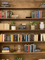 Modern maple wood bookshelf filled with books and decorative items.