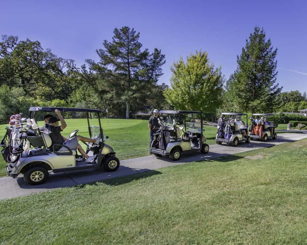 carrello da golf bianco sul campo in erba verde durante il giorno