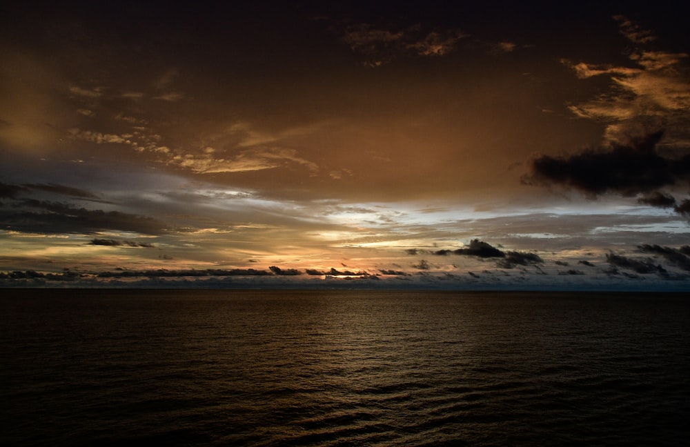 body of water under cloudy sky during daytime