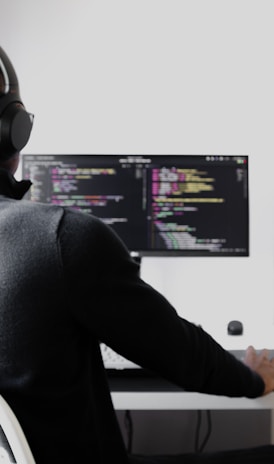 man in black long sleeve shirt wearing black headphones sitting on chair