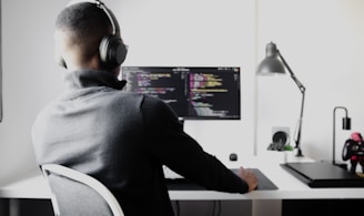 man in black long sleeve shirt wearing black headphones sitting on chair