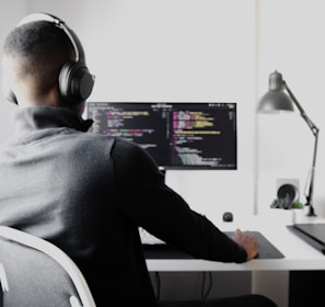 man in black long sleeve shirt wearing black headphones sitting on chair